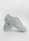 Un par de ML0033 Grey Floater sneakers, hechos a mano en Portugal, con una superficie texturizada, presentados sobre un fondo blanco liso.