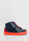 MH0094 Noir W/ Orange high-top sneakers avec semelles et garnitures rouges, et lacets rouges sur fond blanc uni. Fabriquées à la main à partir de cuir italien de première qualité, ces chaussures élégantes sont fabriquées sur commande dans le respect de l'éthique.
