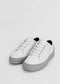 A pair of ML0061 White W/ Grey, handcrafted in Portugal using premium Italian leathers, with white laces and grey rubber soles, is placed on a plain white background.
