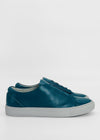Side view of ML0083 Blue Leather, a pair of teal low-top sneakers with white soles, handcrafted in Portugal using premium Italian leathers, on a plain white background.