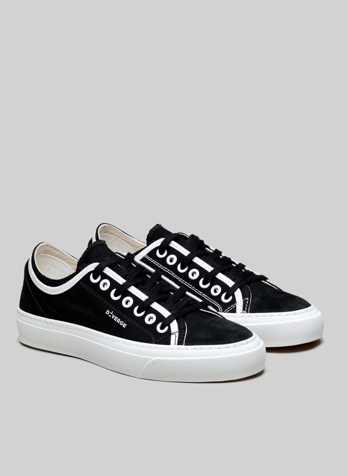 Low top white and black sneakers by Diverge, promoting social impact and custom shoes.