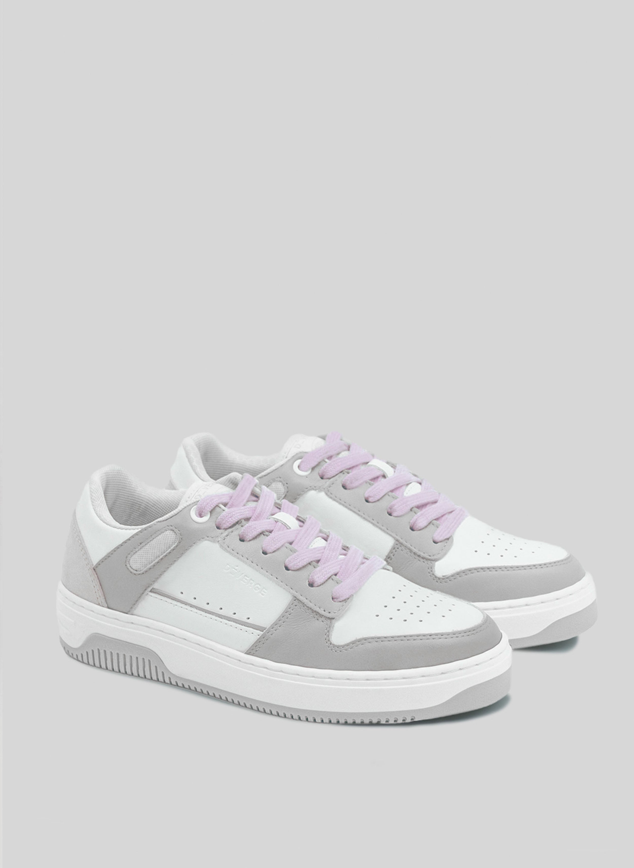 Ein weißer und grauer Sneaker mit lila Schnürsenkeln von Diverge , der durch das imagine-Projekt soziale Auswirkungen und individuelle Schuhe fördert.