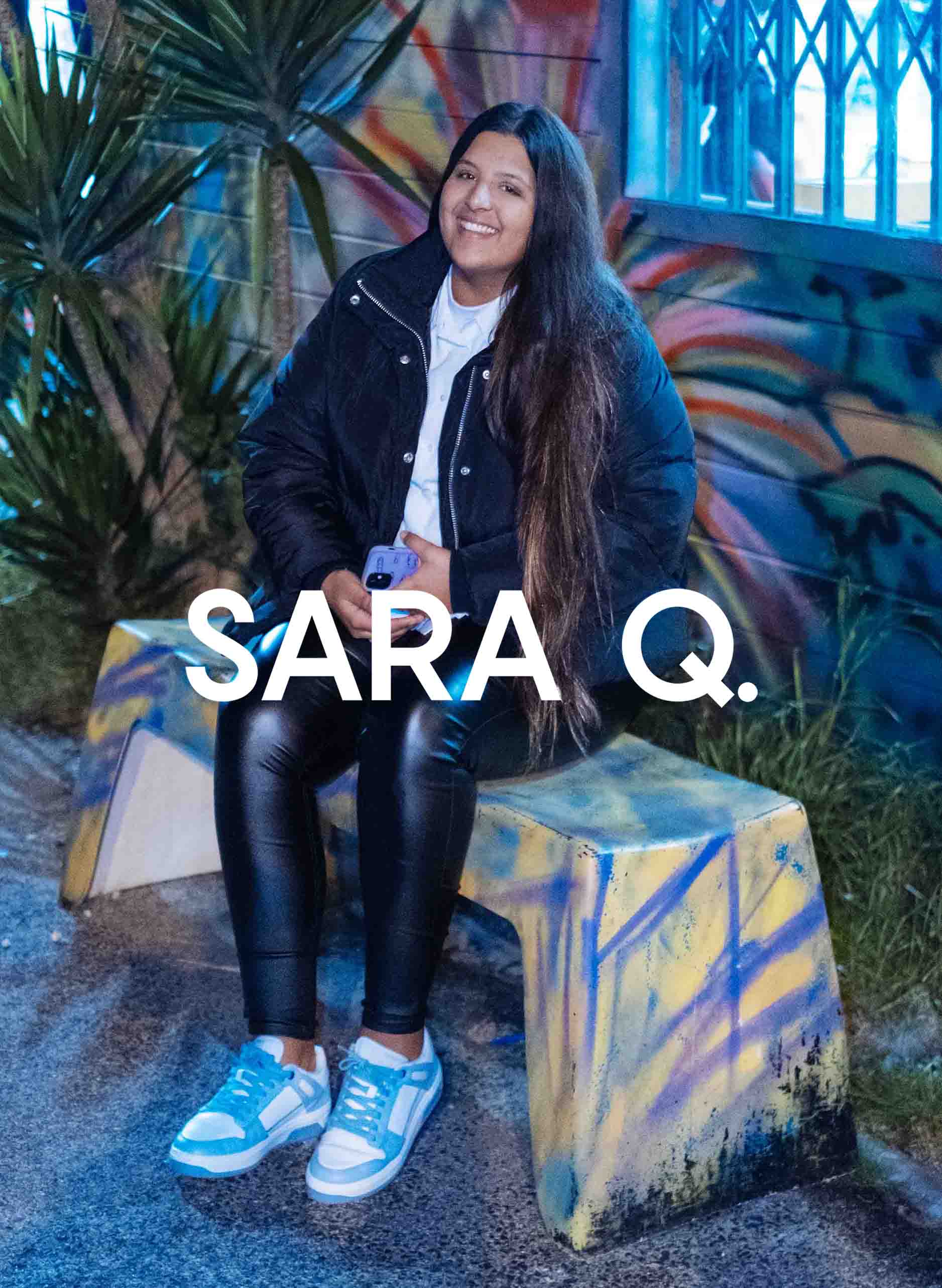 Sara sentada en un banco sonriendo, con Diverge sneakers, promoviendo el impacto social y el calzado personalizado a través del proyecto Imagine. 
