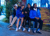 Cuatro personas sentadas en un banco frente a un graffiti, vistiendo Diverge sneakers , promoviendo el impacto social y el calzado personalizado a través del proyecto imagine. 