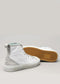 The TH0025 by Nicole are white high-top sneakers handcrafted in Portugal with gray accents and gum soles. One shoe is upright, the other on its side, showcasing a honeycomb tread pattern. Ethically produced for style and sustainability.