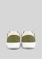Back view of the V12 Olive W/ Off White handcrafted sneakers in green and white, featuring white soles, set against a gray background.