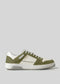 The V12 Olive W/ Off White is a white and green sneaker showcasing a sleek design with a white sole. It features perforated side details and is crafted from premium leather for added luxury and elegance.