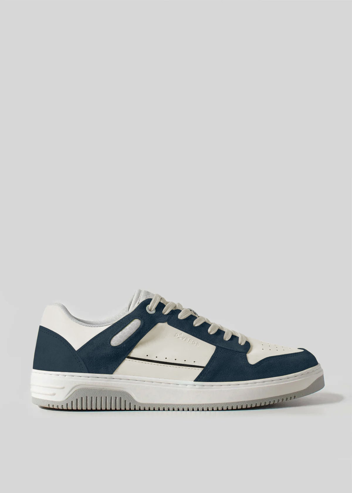 Crafted from premium Italian leathers, the V13 Deep Blue W/ Off White is a white and dark blue low-top sneaker featuring perforated side details, a textured rubber sole, and laces. Handcrafted in Portugal, it embodies timeless elegance and is set against a plain gray backdrop.
