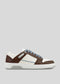 The V14 Brown W/ Off White is a handcrafted sneaker from Portugal, showcasing white and brown colors, light blue laces, a textured sole, and perforated side details.