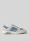 The V17 Lake Blue W/ Bone is a retro-future sneaker in gray and blue with a white sole, lace-up design, and subtle perforated detailing on the side. It's handcrafted in Portugal from premium Italian leathers.