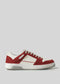 The V18 Off White W/ Scarlet is a handcrafted sneaker combining suede and premium Italian leather in red and white with white laces, a textured rubber sole, and retro-future design influences, all set against a plain gray background.
