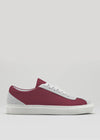 The V19 Ruby W/ Bone is a timeless low-top sneaker in maroon and white, handcrafted in Portugal from premium Italian leather, featuring white laces, a white sole, and a light gray heel accent—shown on a plain light background.