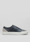 A side view of the V23 Deep Blue W/ Plaster slip-on sneaker, featuring a dark blue design with a white sole and gray accents at the heel and toe, handcrafted in Portugal, set against a light gray background.