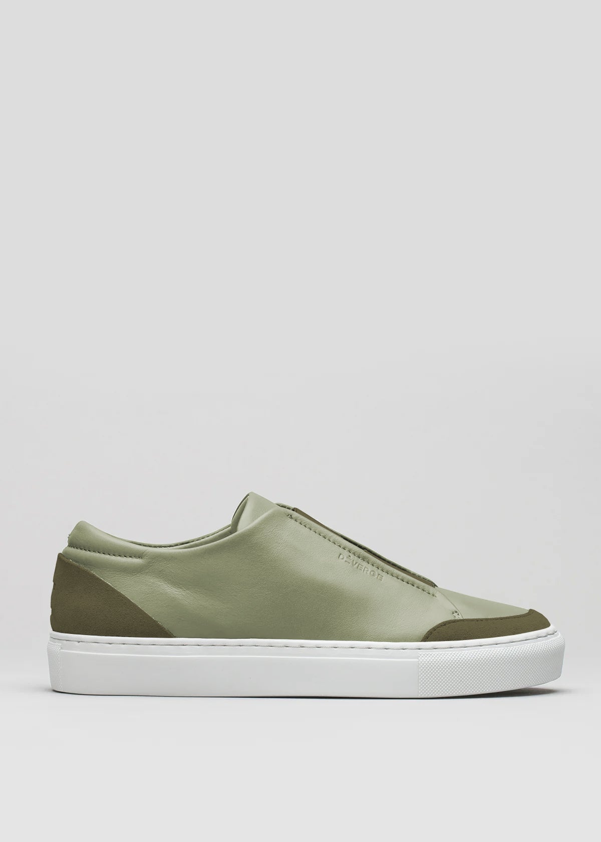 The V24 Pine W/ Olive is a made-to-order slip-on sneaker in Portugal, featuring a premium smooth green leather upper with darker green accents at the heel and toe, and a white rubber sole.