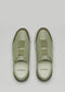 Top view of D'Verge's handcrafted V24 Pine W/ Olive slip-on sneakers, featuring light green color, elastic bands across the top, white soles, and made in Portugal with the brand name on the insole.