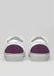 The V25 White W/ Plum sneakers showcase purple heel accents, crafted from premium Italian leathers and presented on a light gray background.