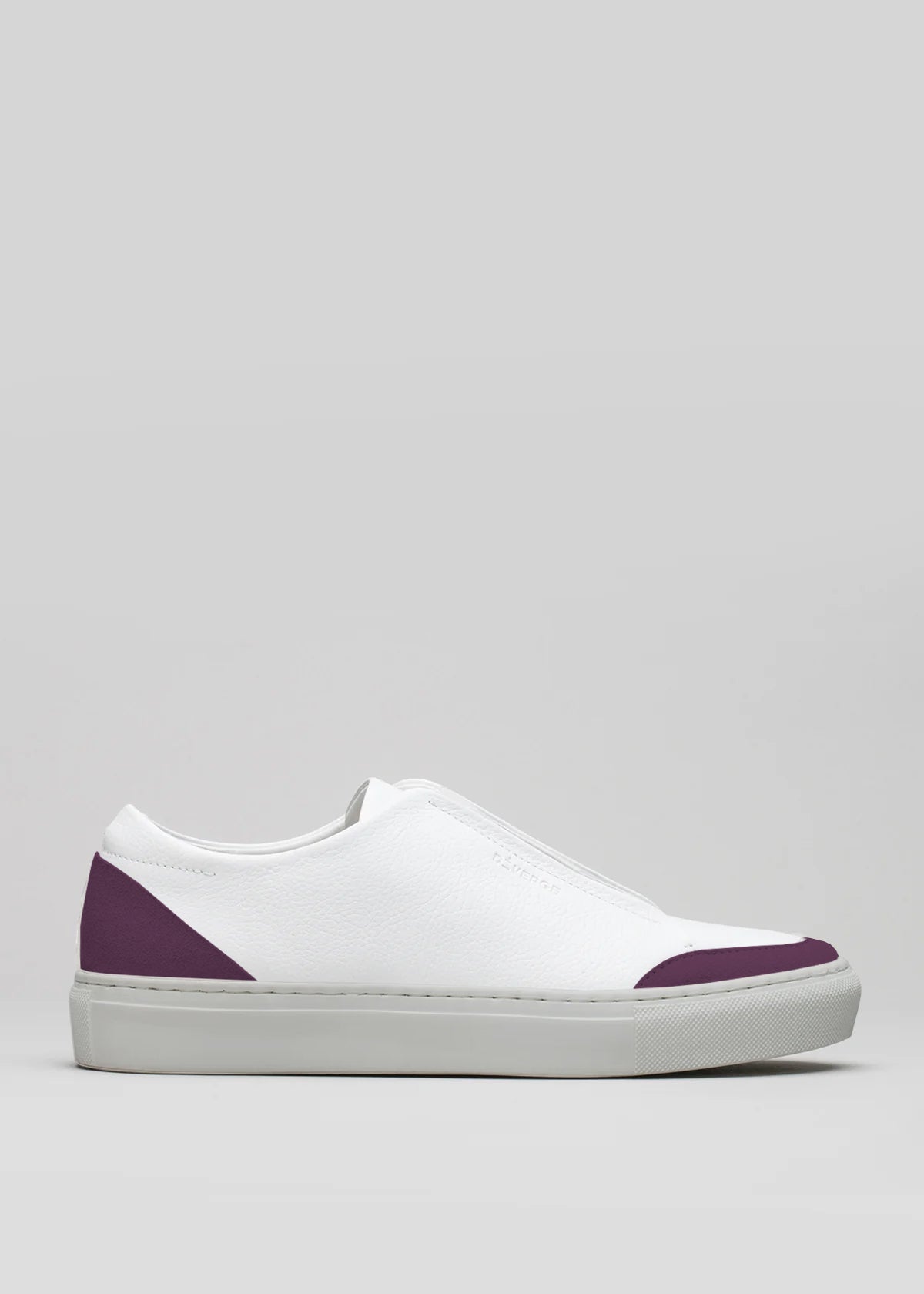 The V25 White W/ Plum is a handcrafted low-top sneaker made in Portugal from premium Italian leathers. It features a white design with plum accents on the toe and heel, a flat sole, and is set against a plain gray background.