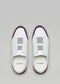 The V25 White W/ Plum slip-on sneakers, viewed from above against a gray background, showcase plum accents. Handcrafted in Portugal, these low tops feature insoles with the "D:VERGE" logo.