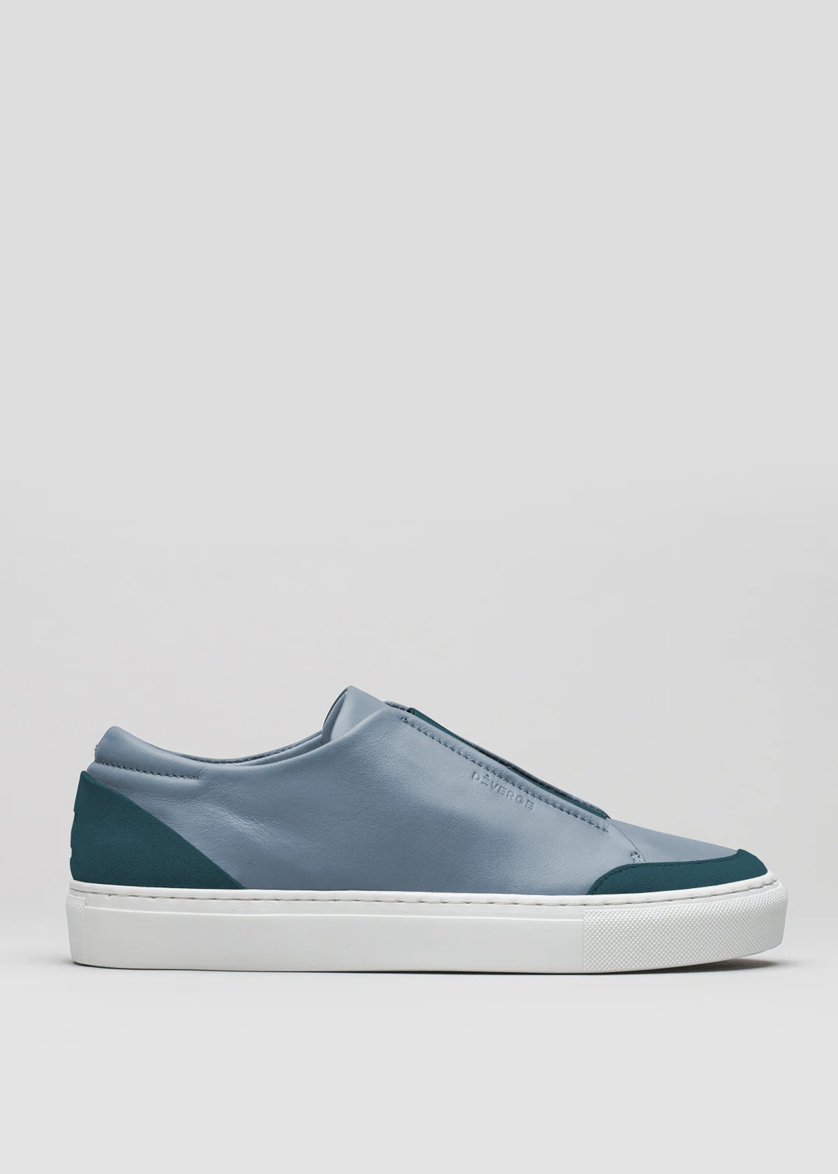 Side view of the V27 Lake W/ Petrol Blue low-top sneaker, crafted from premium Italian leathers with a smooth gray upper, teal accents on the toe and heel, and a white rubber sole against a plain background.