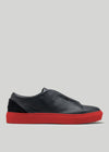 The V48 Deep Blue W/ Red is a premium Italian leather slip-on sneaker in black with red soles, showcased in a side profile against a plain background.