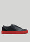 The V48 Deep Blue W/ Red is a premium Italian leather slip-on sneaker in black with red soles, showcased in a side profile against a plain background.