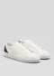 The V52 Off White W/ Plum sneakers feature a minimalist design and purple heel accents, crafted from premium Italian leathers, displayed on a plain background.