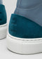 A close-up of the V54 Lake W/ Petrol Blue sneaker's heel, handcrafted in Portugal, highlights blue premium leather and teal suede with a white textured rubber sole and linear detailing on the suede.