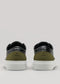 The V57 Black W/ Olive sneakers showcase a premium Italian leather design with black and olive green tones, finished with crisp white soles, set against a neutral background.