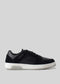 A V4 Black low top sneaker with a white sole on a grey background.