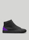 Una sneaker alta in pelle nera con un accento viola sul tallone, su uno sfondo grigio. MH00018 di Diogo.