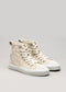 Un paio di V4 Antique White Canvas high-top sneakers con suole bianche su sfondo grigio.