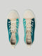 Un paio di scarpe di tela Aqua & Teal viste dall'alto, con lacci bianchi e il marchio "DiVERGE X BUREL " visibile sulla linguetta.