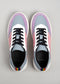A pair of N0002 by Ricky vegan sneakers with pink, purple, and blue panels, and black laces, viewed from above on a gray background.