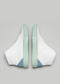 Une paire de V25 Artic W/ Pastel Green sneakers avec des accents bleus sur un fond gris.