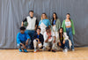 A group of young people wearing custom shoes, posing for a photo on a gym, promoting social impact throught the imagine project.