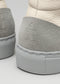 Detalle de la parte trasera de dos V27 Beige Floater high top sneakers con materiales texturados y logotipos en relieve en los talones.