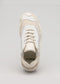 Vista frontale di un'elegante sneaker low top beige e bianca V10 Leather Color Mix Beige sulla linguetta, visualizzata su uno sfondo grigio neutro.