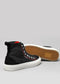A pair of TH0002 by Roni with black canvas uppers, white laces, a white rubber sole, and a distinctive orange interior visible in one shoe on a gray background.