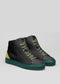 A pair of MH0009 Jamaican Pride high-top sneakers in black with green laces, featuring a gold heel patch and green rubber soles, displayed against a plain gray background.