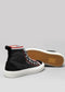 Une paire de chaussures en toile TH0007 Dark Fader avec des couleurs noires, blanches et rouges, sur un fond gris clair.