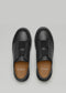 Un paio di scarpe SO0003 Back in Black con cinturini in velcro, su sfondo grigio. Le solette sono marchiate con "D-Verge".