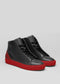 A pair of MH0010 Bred high-top sneakers with red soles on a grey background.