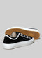 Une paire de chaussures TL0002 by Roni avec des embouts et des semelles blancs, présentée sur un fond gris clair.
