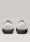 Un paio di SO0014 ALPINE NOIR low top sneakers con suola bianca e linguette posteriori, presentate su uno sfondo grigio chiaro.