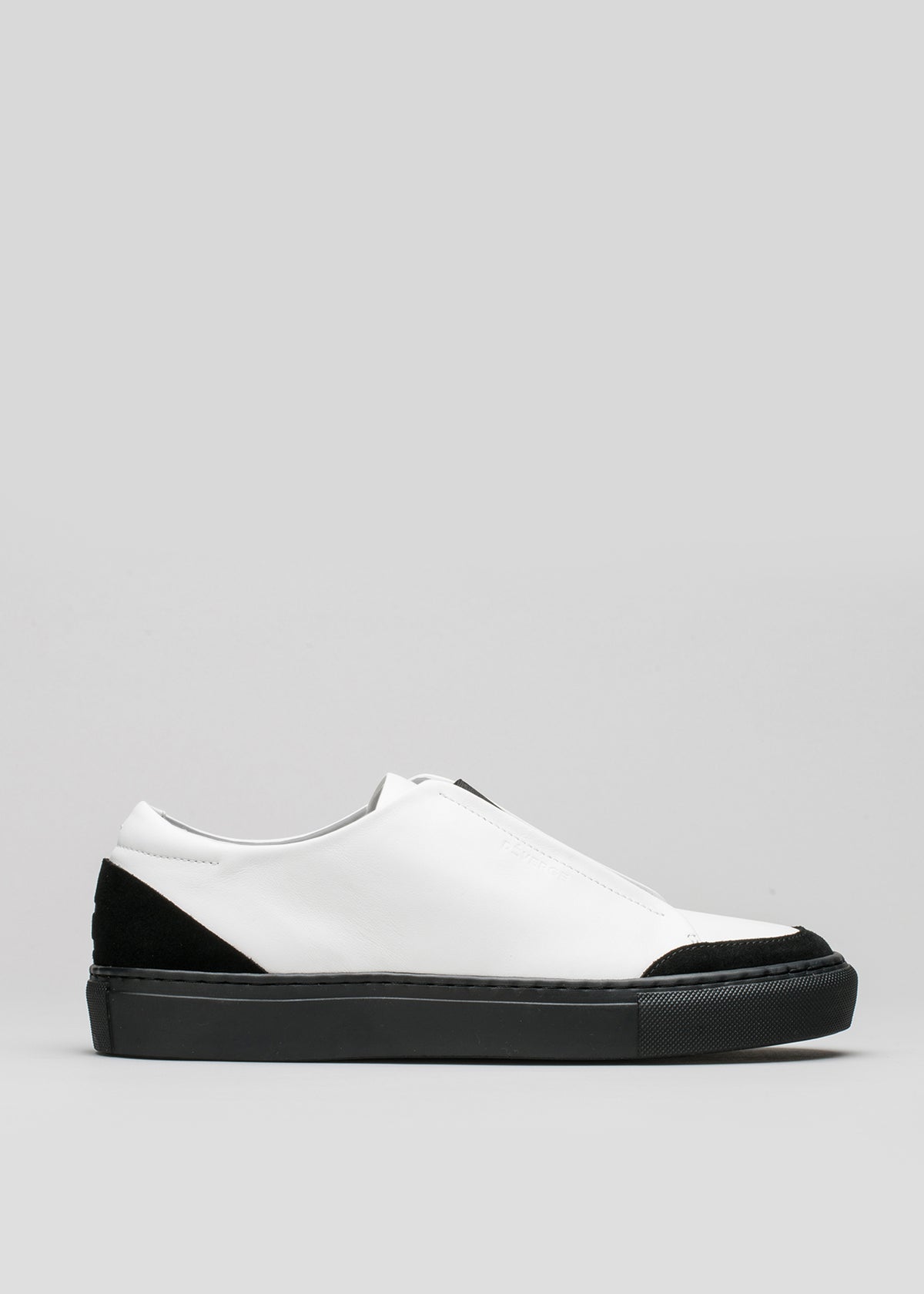 A white slip-on sneaker with a black sole and toe cap, displayed against a light grey background.