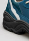 Close-up of a L0008 BLACKGL_PARIS showcasing its teal and white leather upper and textured black rubber sole.