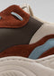 Vista ravvicinata di una sneaker bassa V19 Leather Color Mix Brown che mostra i dettagli degli strati multitessuto in marrone, blu e beige, con cuciture e lacci visibili.