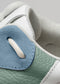 Nahaufnahme eines Low-Top-Sneakers L0007 Cotton Candy mit detaillierten Nähten und strukturierten Stoffen in blauen, grünen und weißen Farbtönen.