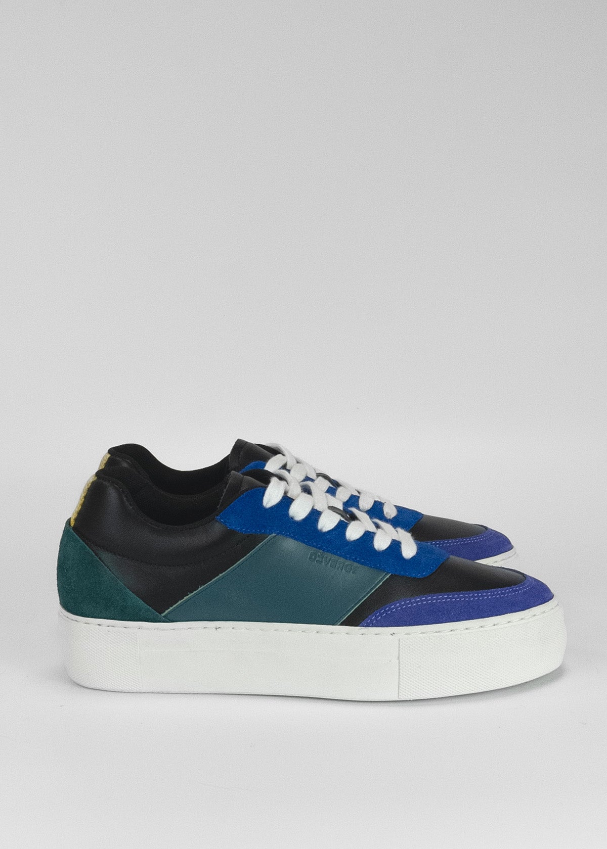 Un par de elegantes sneakers de cuero con paneles en azul eléctrico, negro y blanco.
