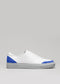 Weißer Ledersneaker mit V14 Electric Blue W/ Lilac-Akzenten an der Ferse und an der Spitze auf grauem Hintergrund.
